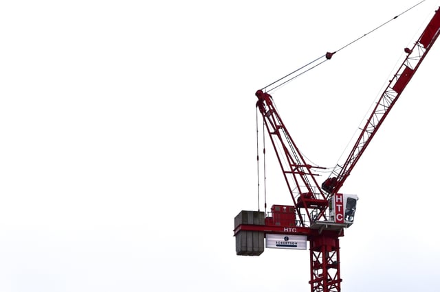 red-construction-crane-against-white-sky